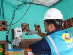 Petugas PLN sedang melakukan pemasangan kWh meter _Advanced Metering Infrastructure_ (AMI) pada rumah pelanggan yang berada di daerah Jatinegara, Jakarta Timur.