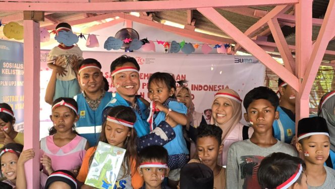 Manager PLN UP3 Bintaro, Hendar Prisnadianta Yanuardhana (tengah) berfoto bersama sambil menggendong salah satu anak didik di Taman Baca Amalia